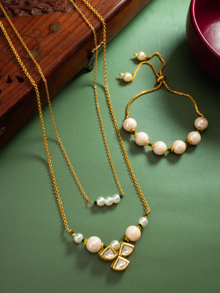 Refined necklace and bracelet set with a floral blossom design, white pearls, and kundan work.