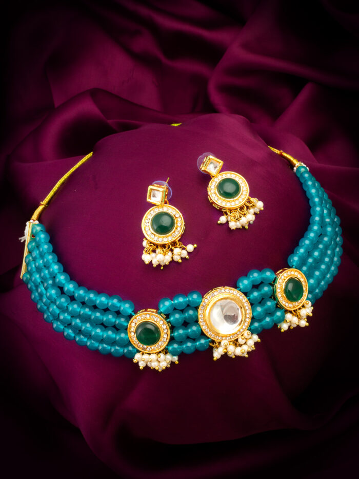 Graceful kundan jewelry set with emerald-colored stones and bead accents.