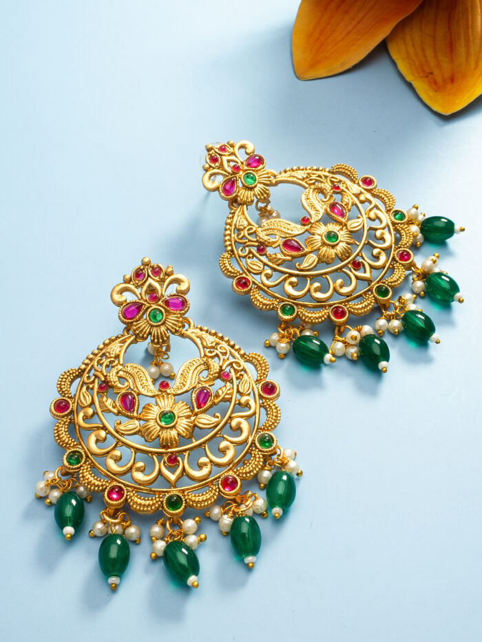Ethnic-style gold drop earrings with green bead accents and floral designs.