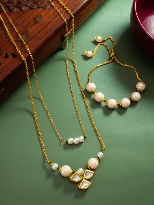 Refined necklace and bracelet set with a floral blossom design, white pearls, and kundan work.