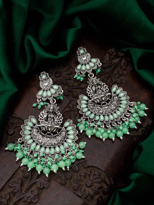 Oxidised silver temple earrings featuring a blooming floral design with an emerald-colored accent.