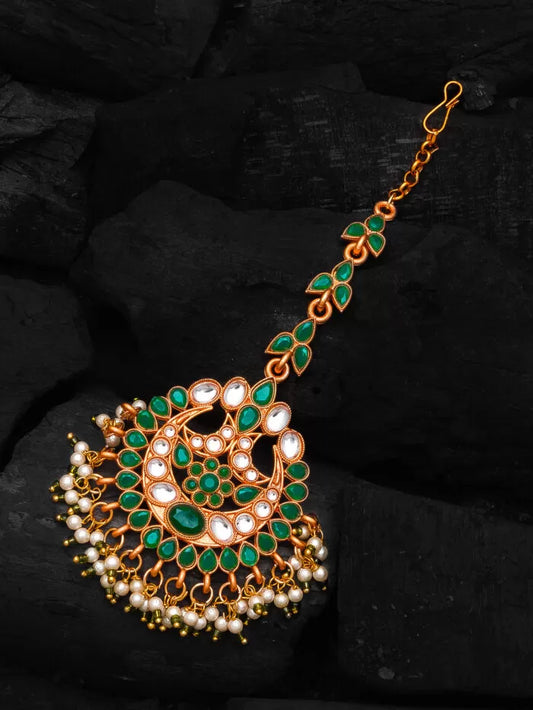 Elegant mang tikka featuring an emerald-colored stone with a subtle glow.
