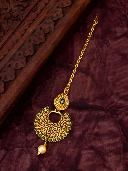 Stunning maang tikka featuring an emerald-colored stone with a radiant shine.
