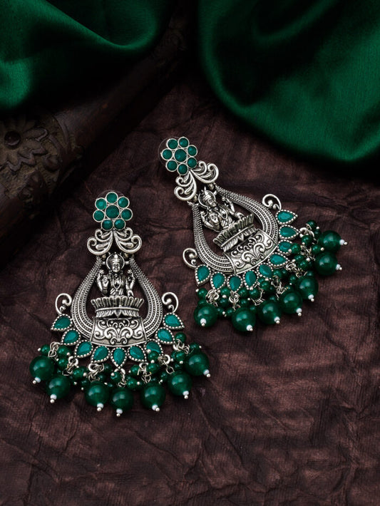 Mystical oxidised silver temple earrings with an enchanting emerald-colored stone.