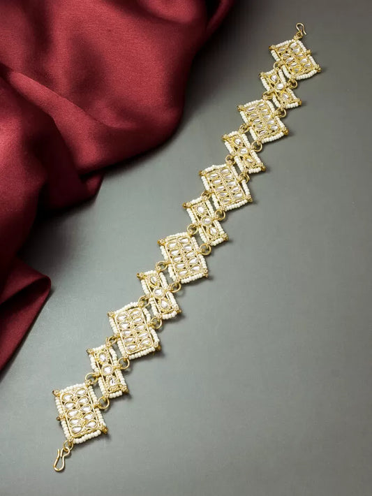 Elegant gold maang tikka (another spelling for mang tikka) with a graceful design.