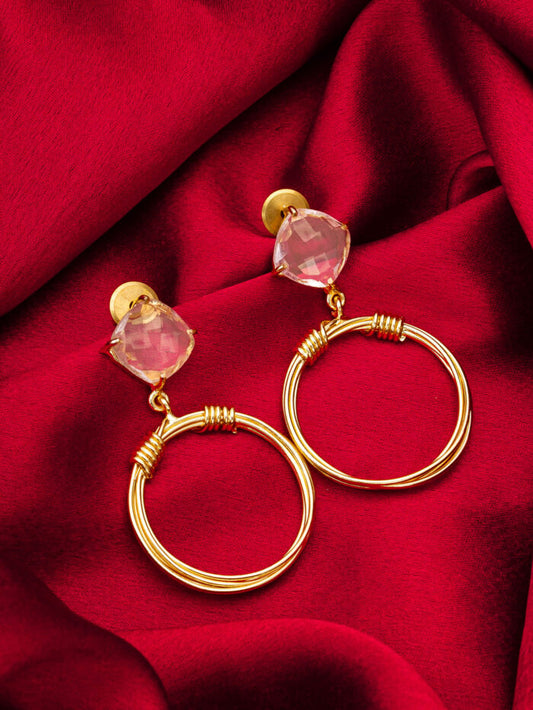 Hoop earrings with a golden loop design featuring white crystals and a twisted element.