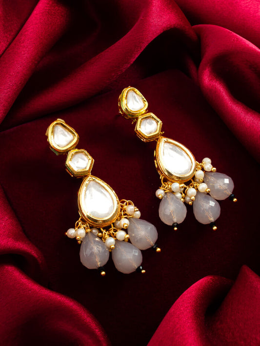 Elegant drop earrings with white kundan work, resembling regal dewdrops.