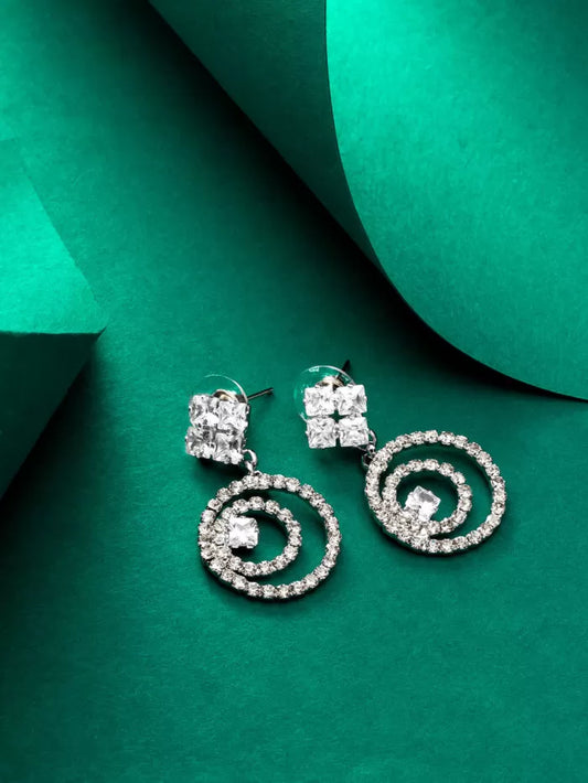 Elegant silver drop earrings with a spiral design and 'AD' (American Diamond) stones.